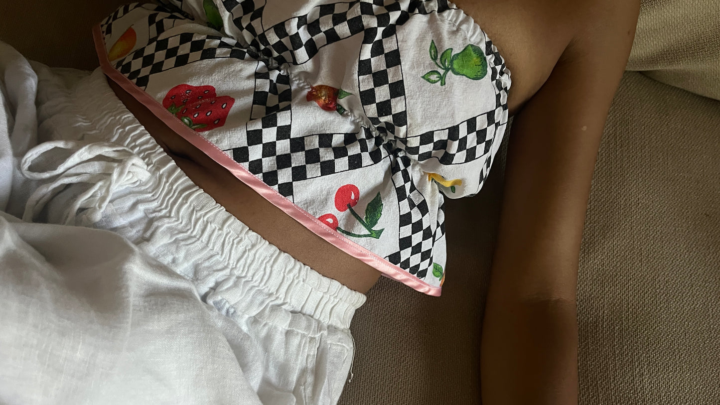 Close-up of a person wearing a patterned skirt with checkered and floral designs.