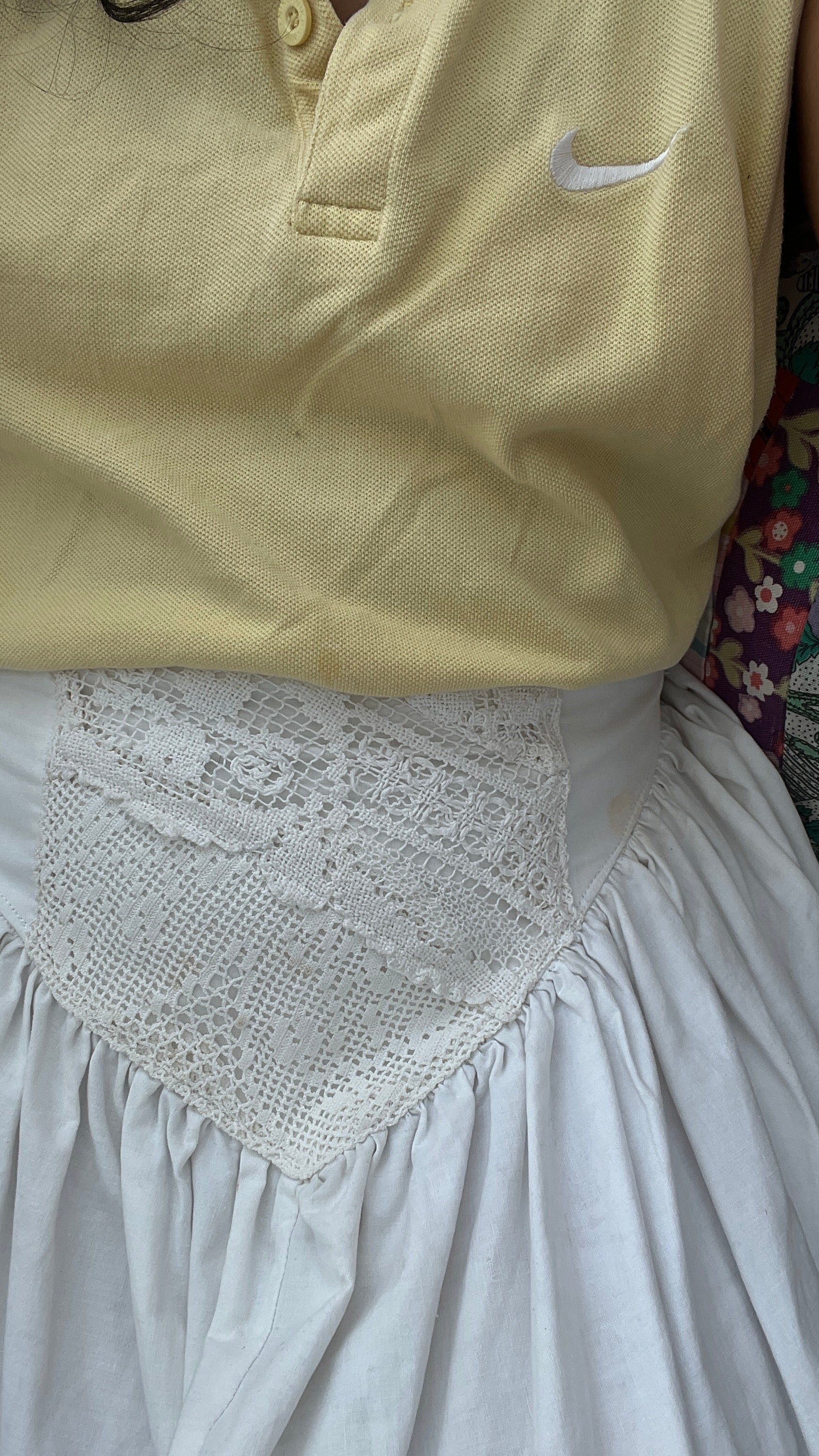 Butter yellow nike polo worn over a white Yllin Saba cotton skirt.