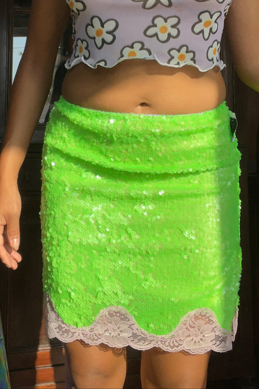 Person wearing a floral top and green skirt indoors